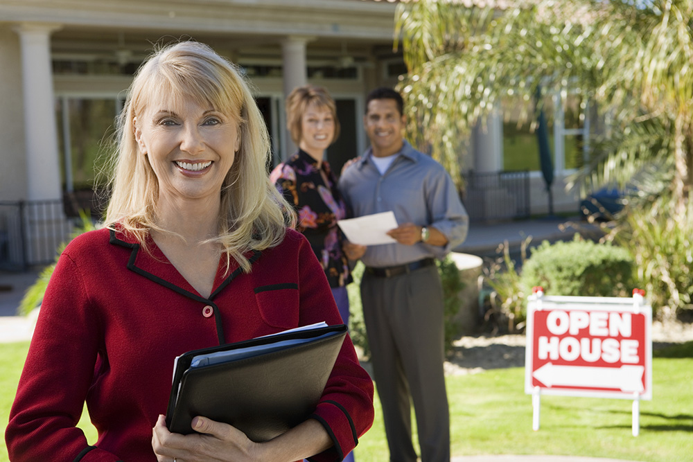 Smiling Real Estate Agent with New Homeowners